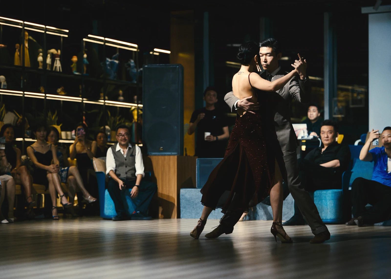 Ballroom couple performing in a lounge while guests watch from nearby seating