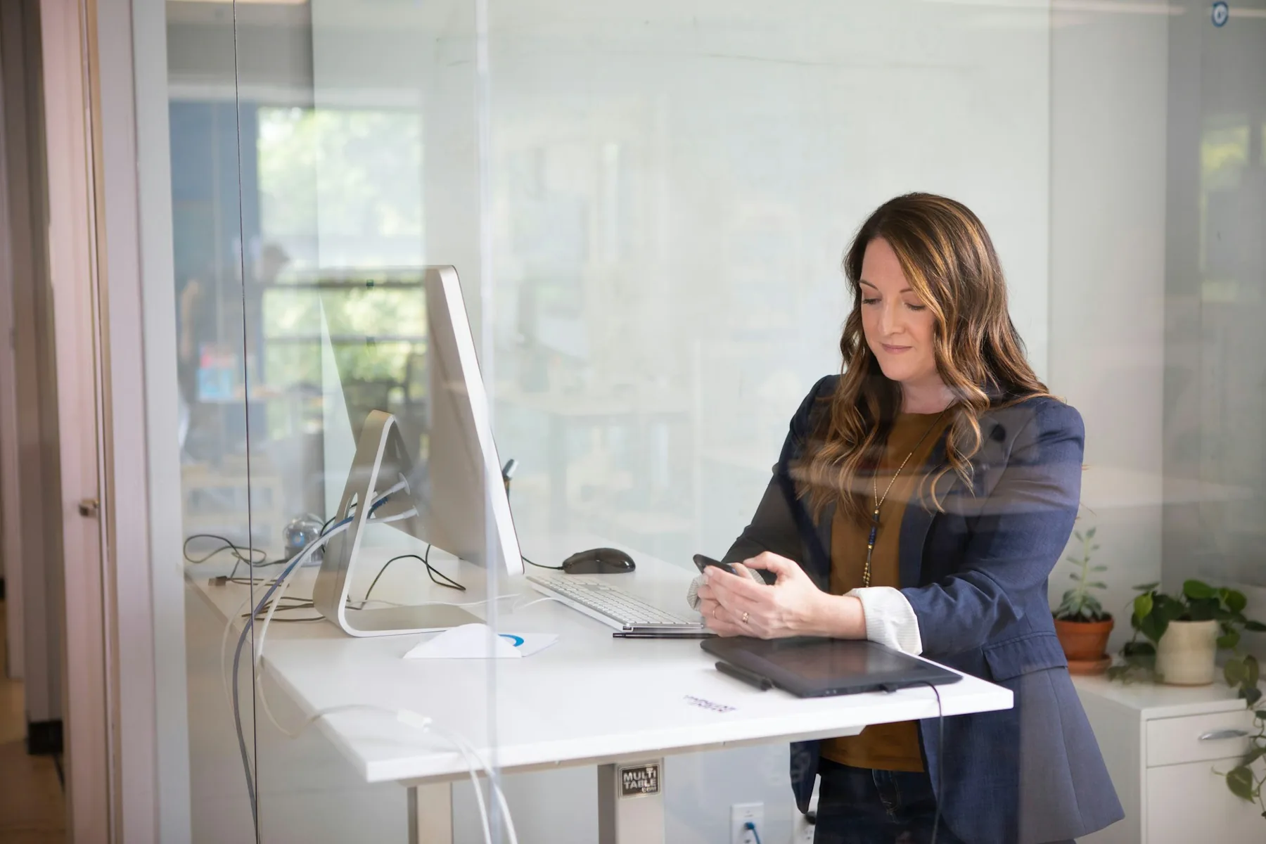 Care manager working at a laptop in a bright professional workspace