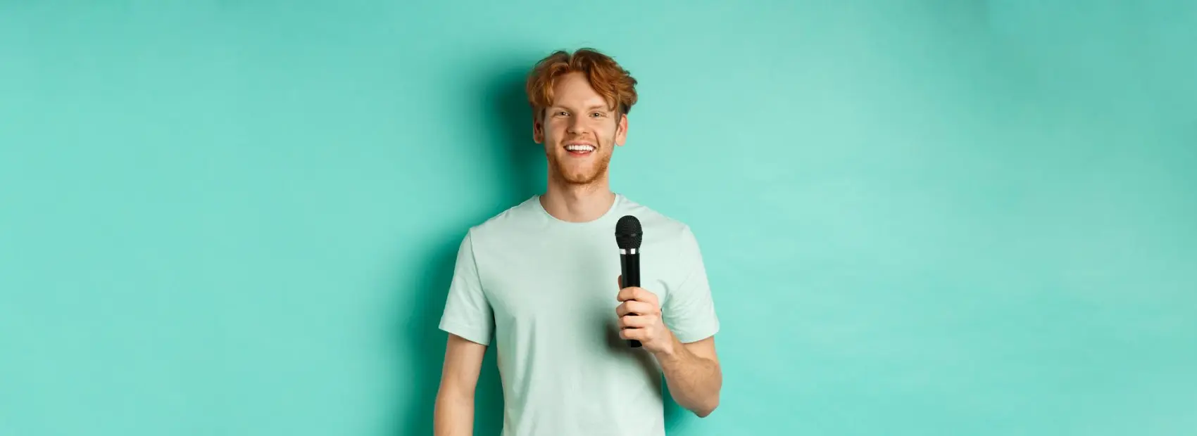 Cruise activity host holding a microphone and smiling
