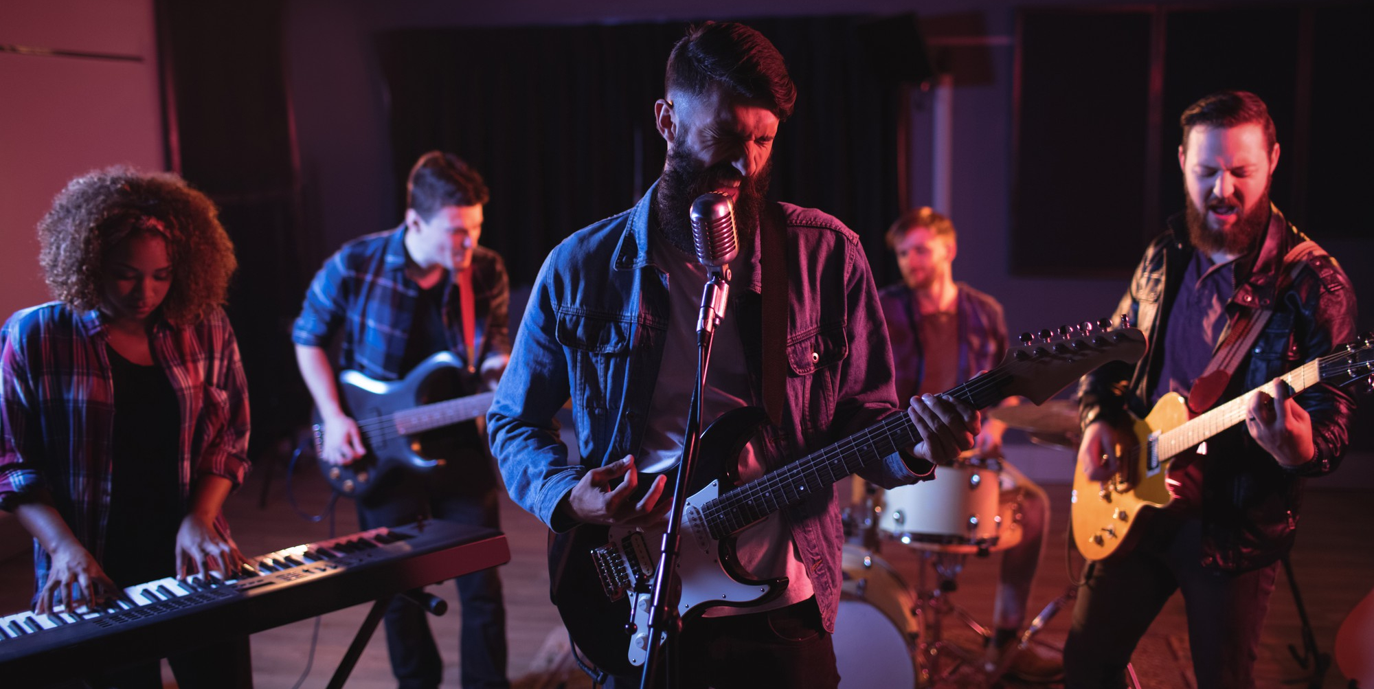 Four-piece party band performing under colorful stage lights